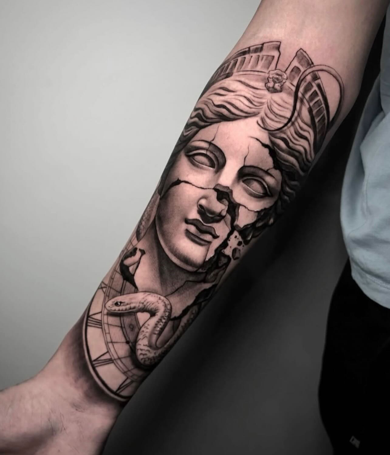 Broken classical statue with snake & clock